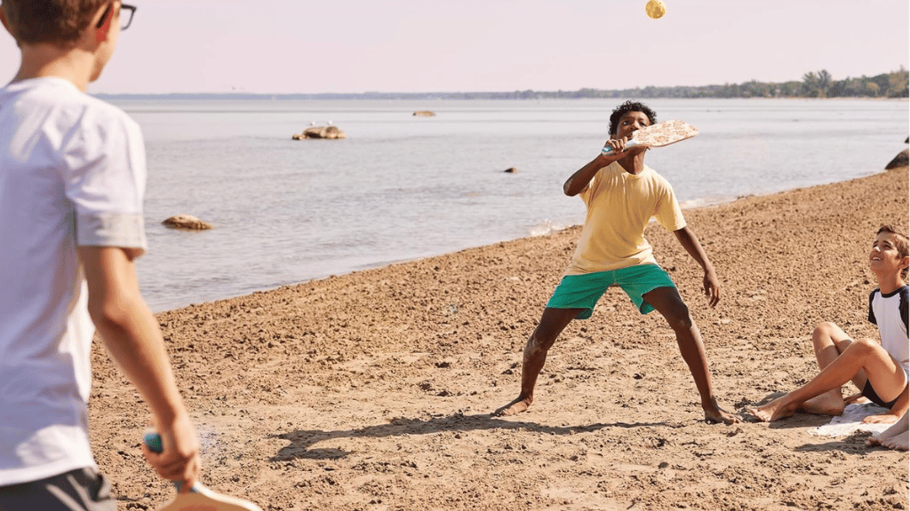 kids playing pickleball on beach